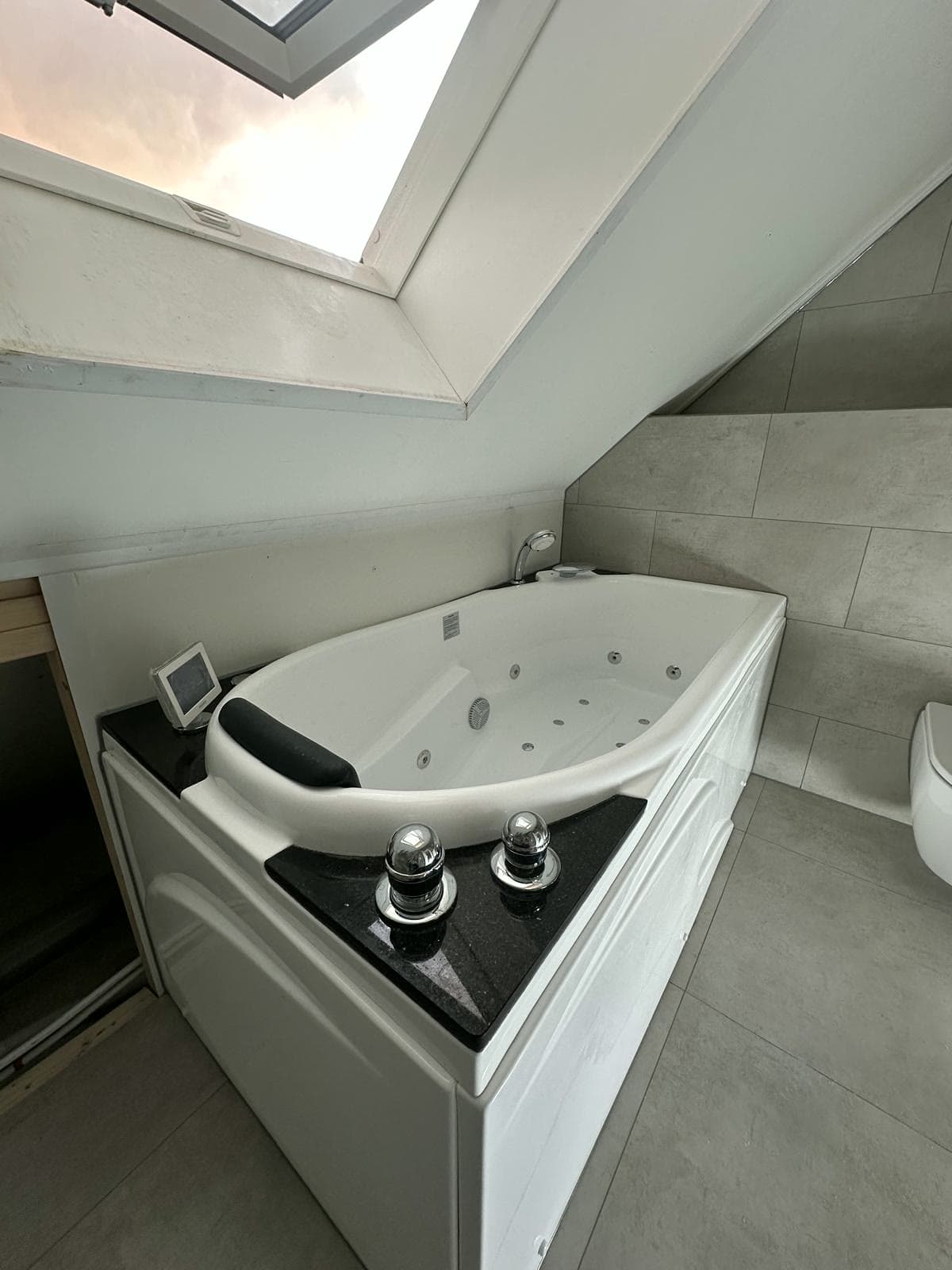 Bad onder het dakraam in de nieuwe badkamer