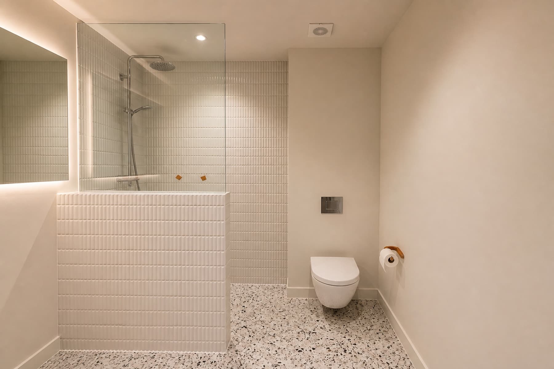 Gerenoveerde badkamer in Amsterdam met glazen douchewand en lichte reliëftegels